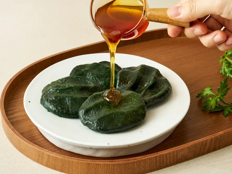 쑥개떡에 조청을 끼얹는 모습